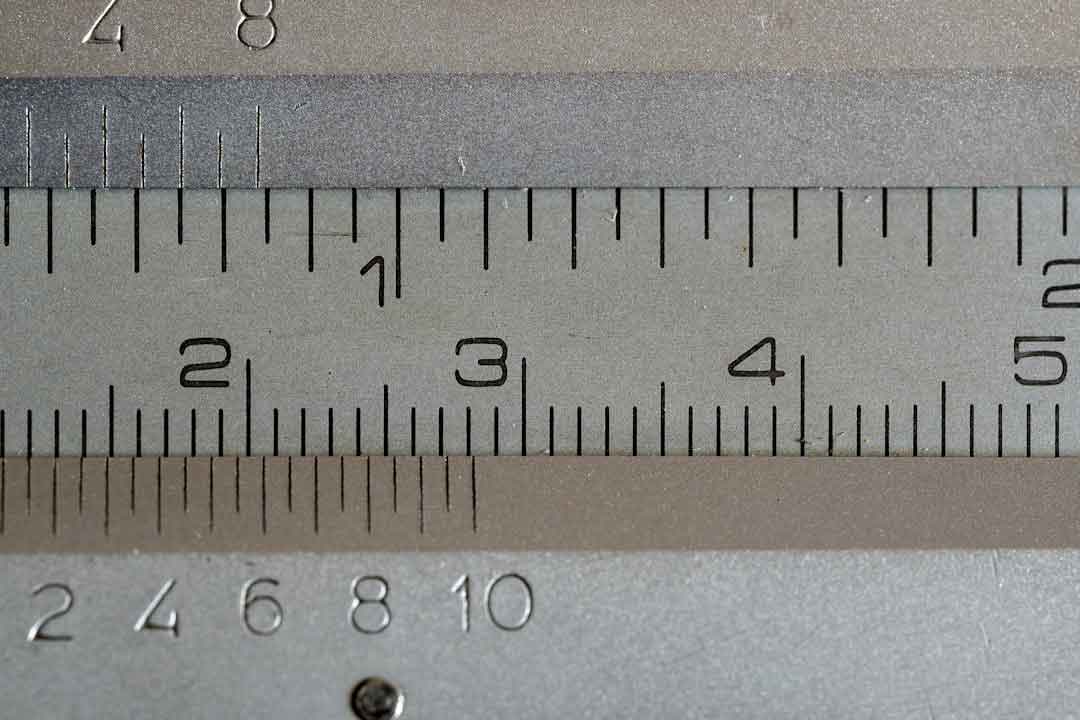 Person measuring inseam with a tape measure