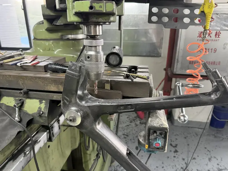 Bottom bracket area of a carbon bike frame clamped in a drilling and machining jig