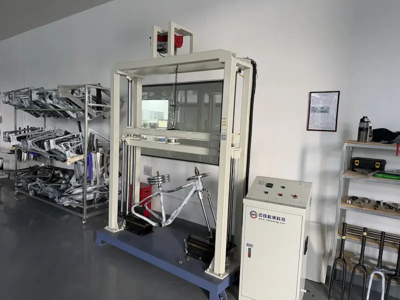 Carbon frame clamped in a fatigue test rig applying repeated loads