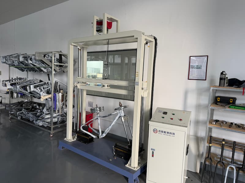 A carbon bicycle frame set up in a load-testing fixture
