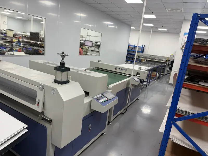 CNC cutting machine cutting carbon fiber plies in a clean production room