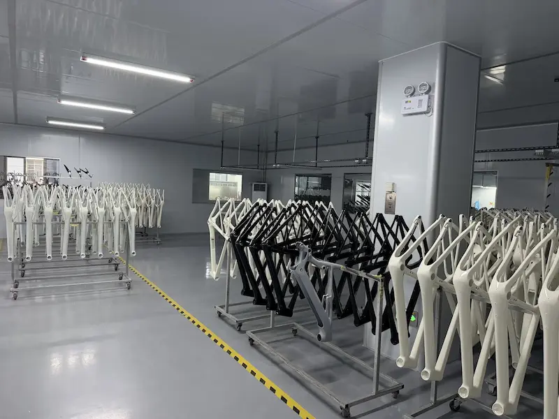 Painted carbon frames in white and black staged in a clean finishing room